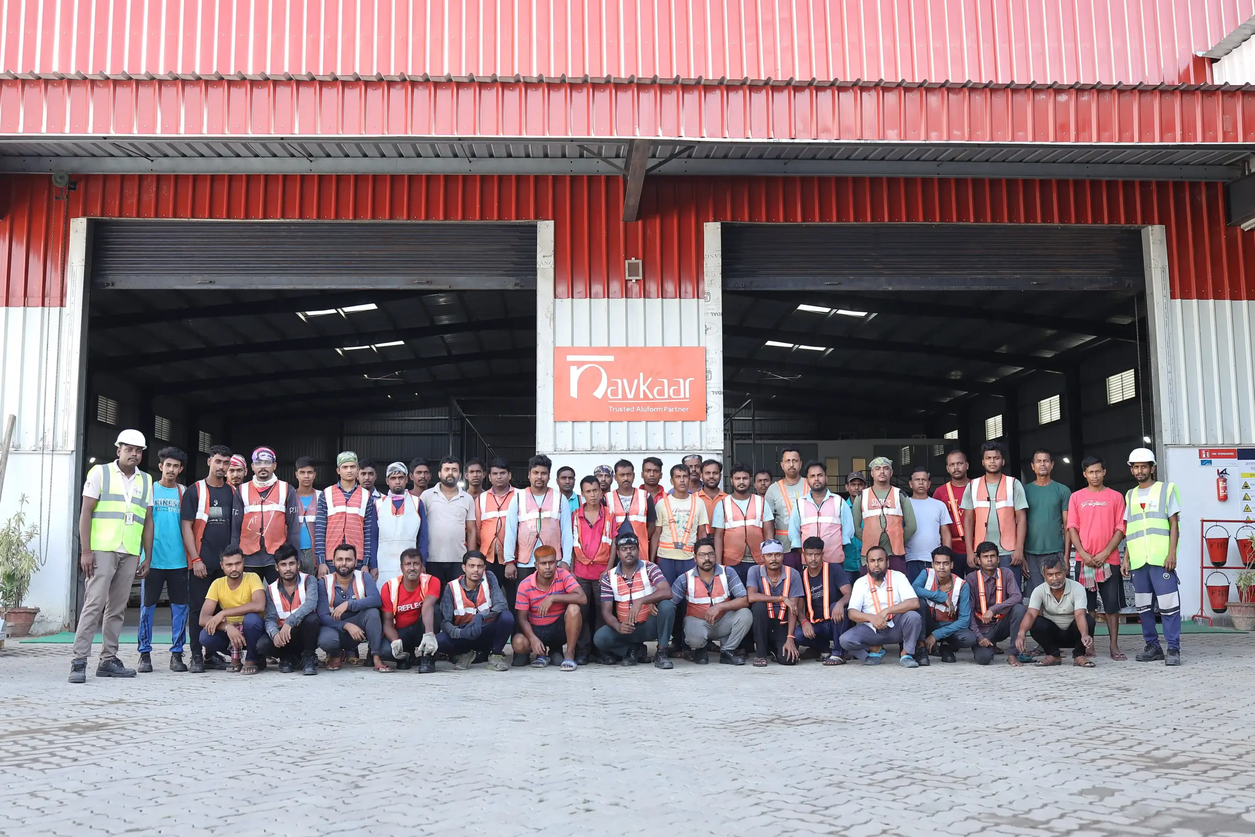 Navkaar factory team in safety vests gathered outside the fabrication shed