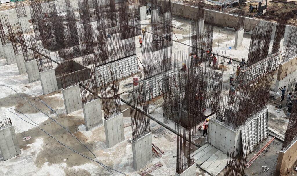 Concrete columns and walls with exposed reinforcement bars on site, with aluminium wall formwork panels in place