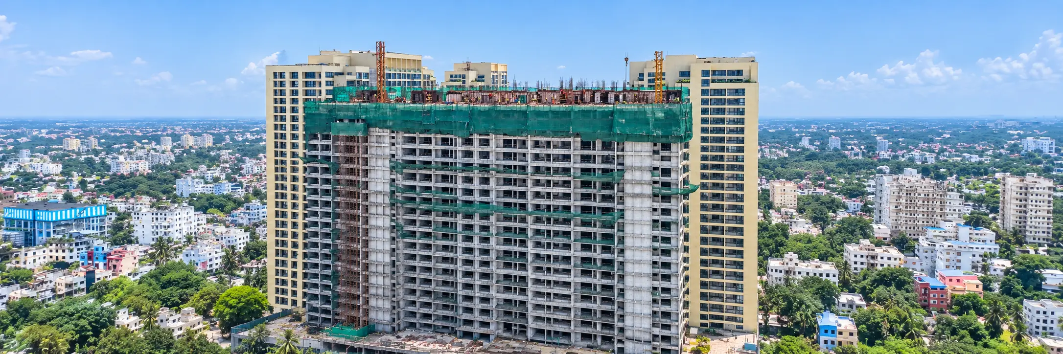 A tower under construction with its top floors wrapped in safety netting