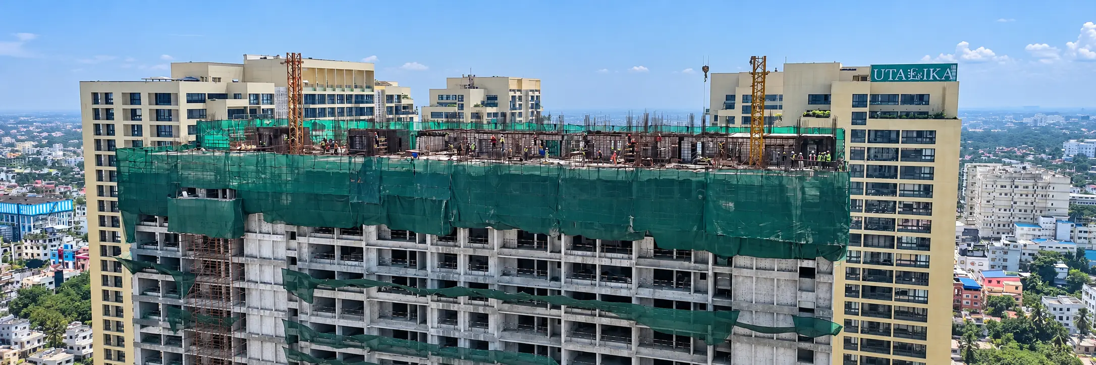 A tower under construction with its top floors wrapped in safety netting